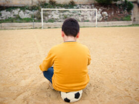 menino triste futebol campo bola