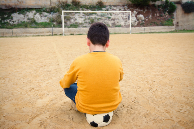 menino triste futebol campo bola