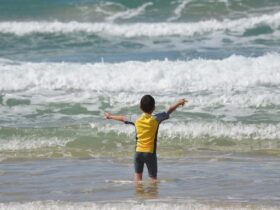 criança praia mar onda