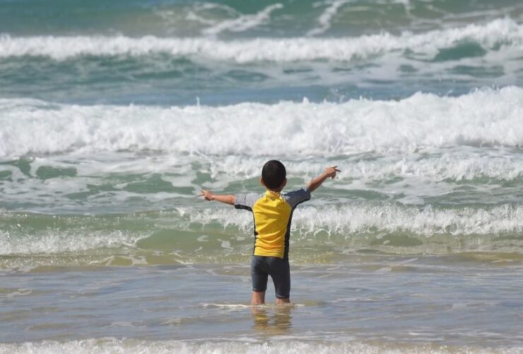 criança praia mar onda