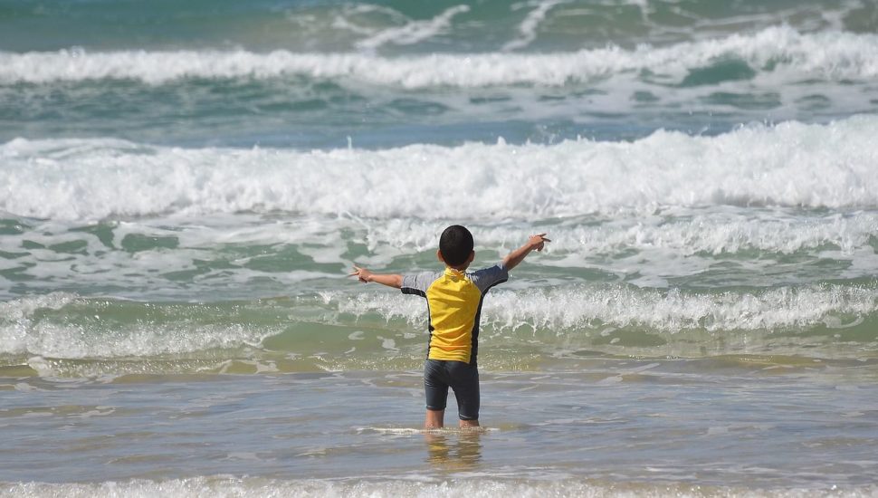 criança praia mar onda