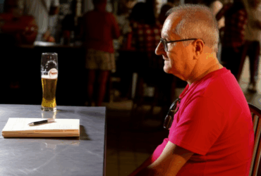 Luiz Coelho Medina sentado no bar
